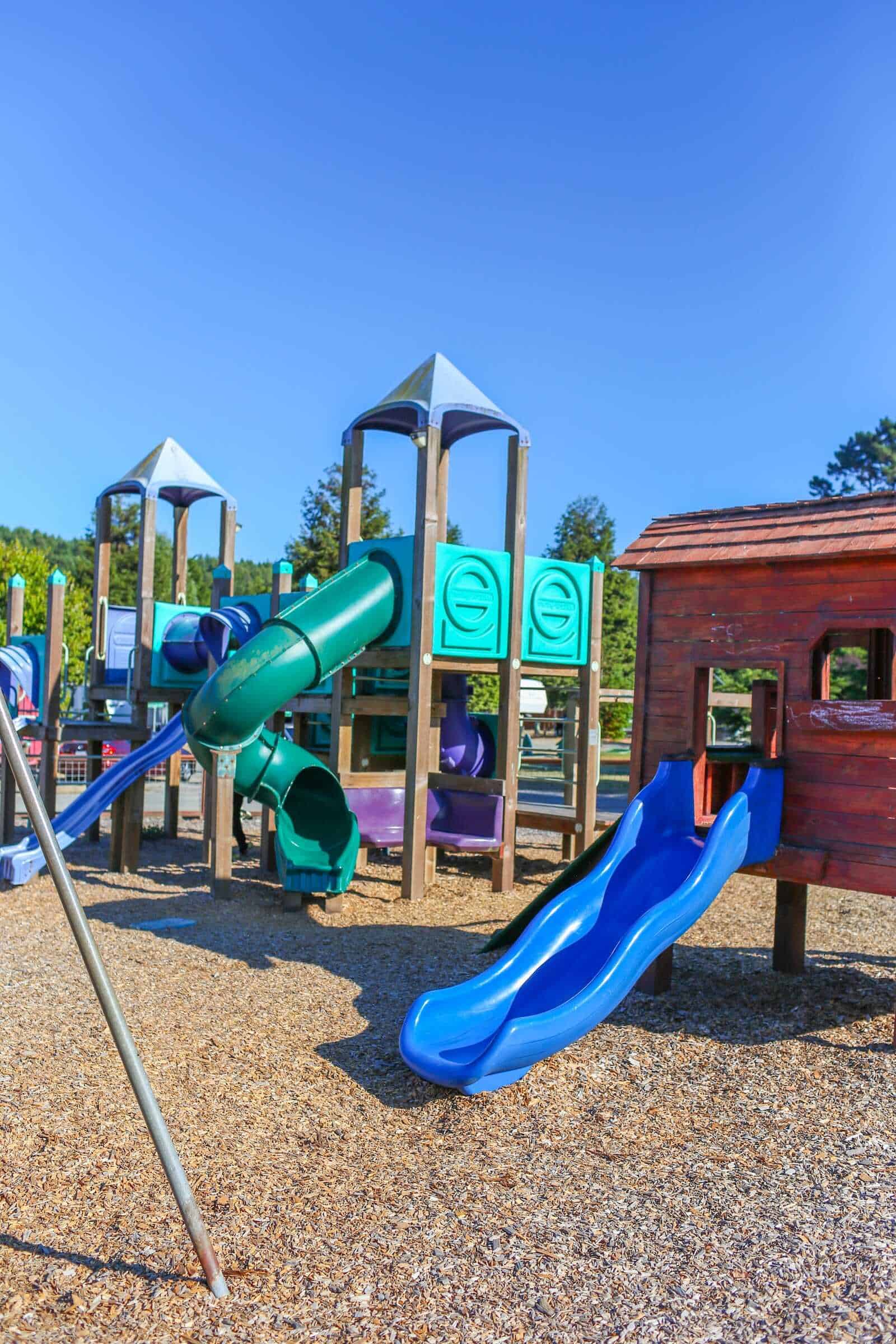 Colorful outdoor playground with slides and playhouse, ideal for family fun in California.