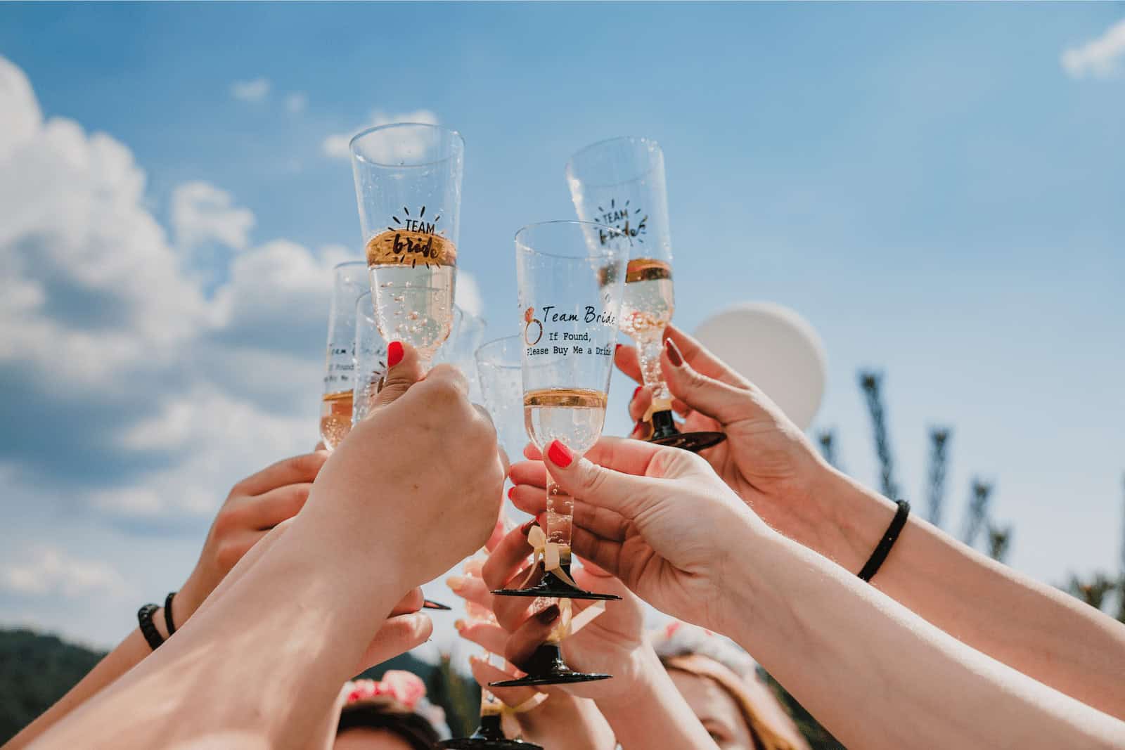 Celebrating a wedding toast with champagne glasses at California Nomad event.