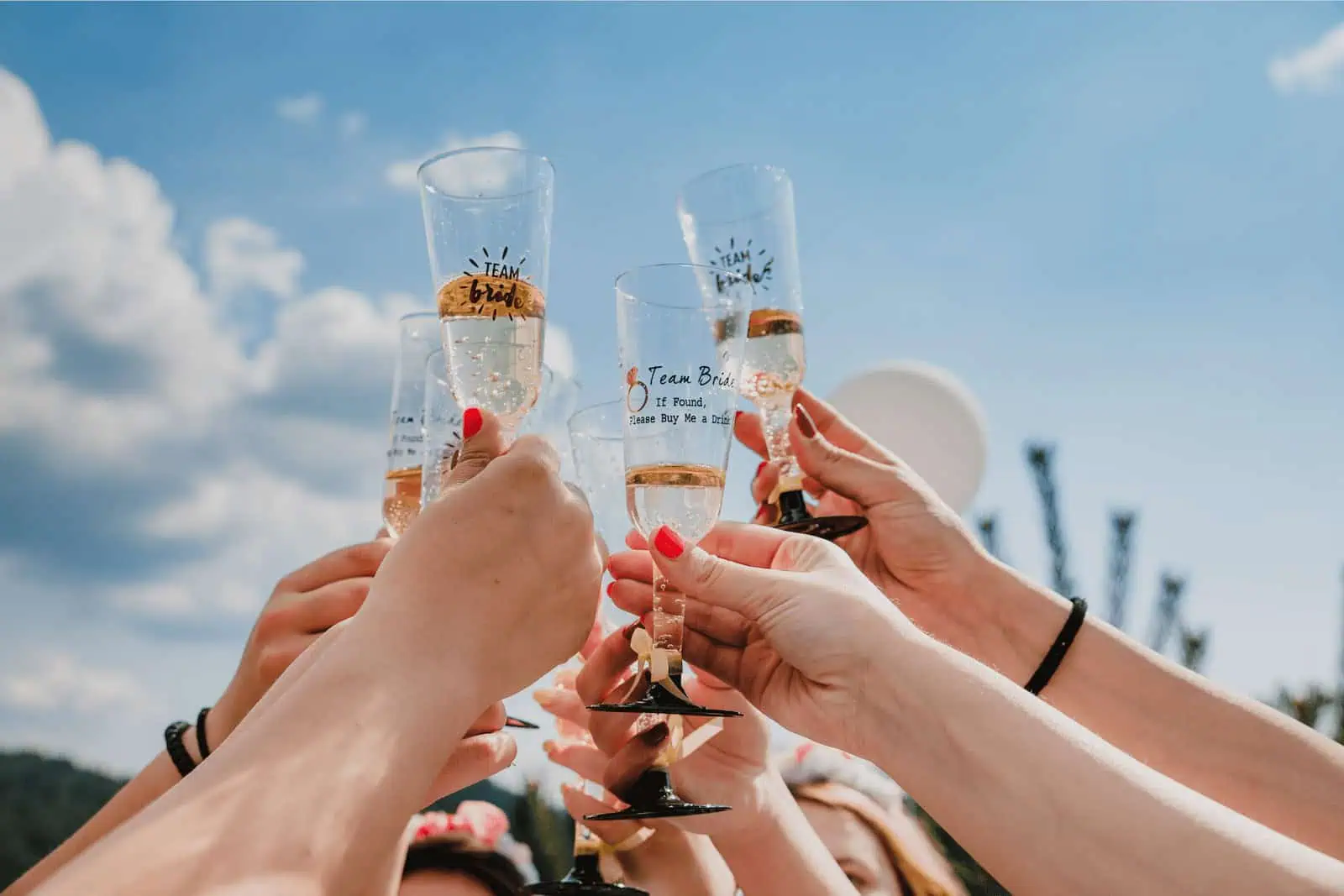 Celebrating a wedding toast with champagne glasses at California Nomad event.
