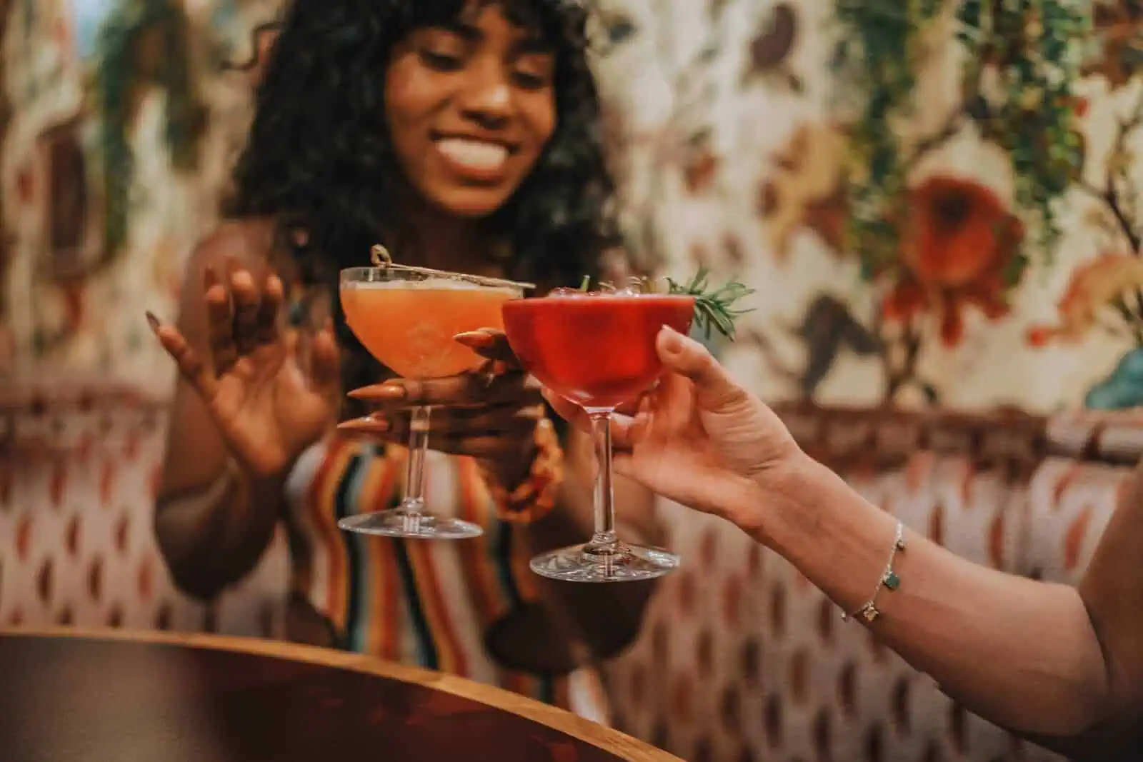 Vibrant cocktails being raised in a lively, stylish restaurant celebrating California culinary culture.