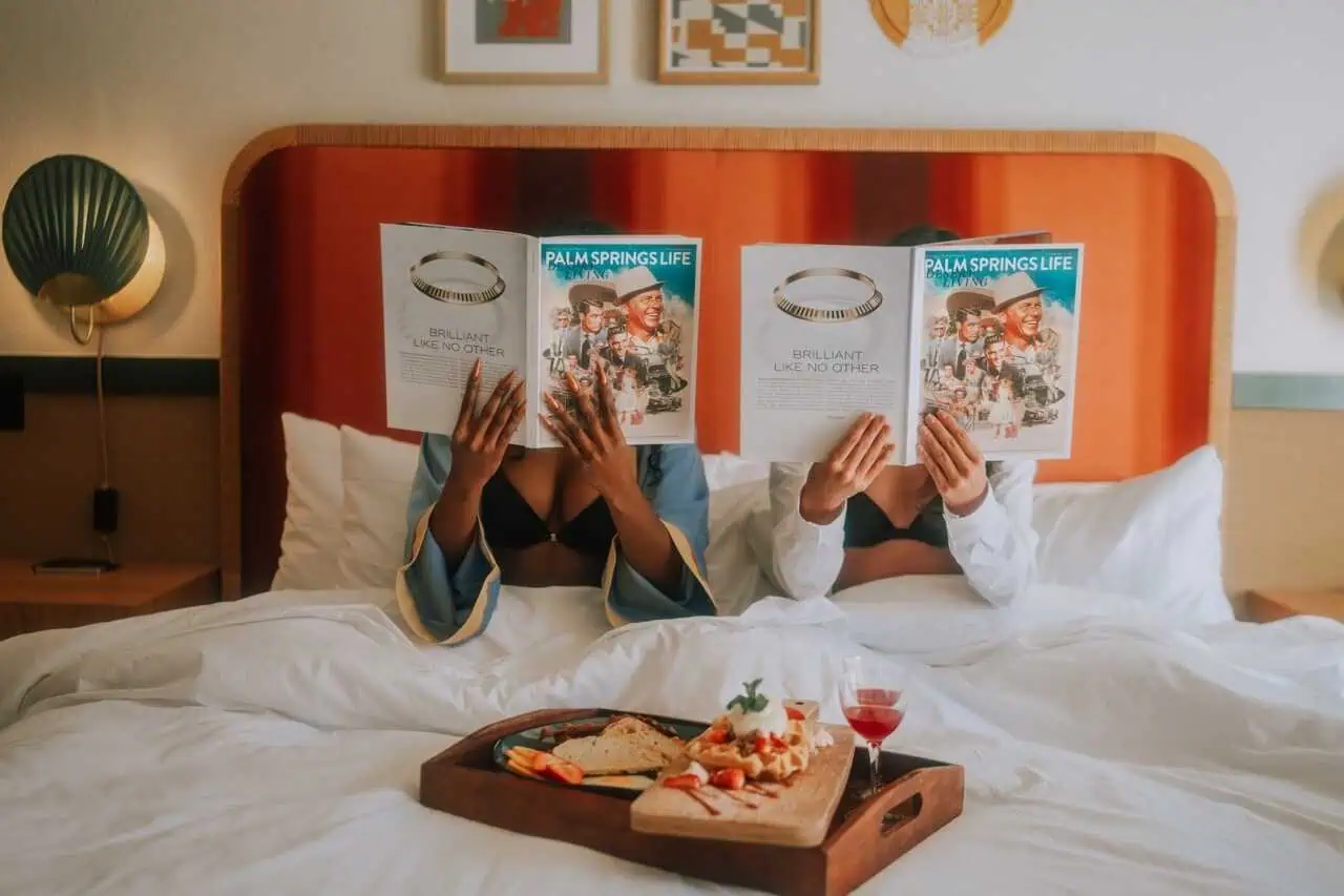 Magazine reading in a hotel room with breakfast tray on bed - California Nomad.