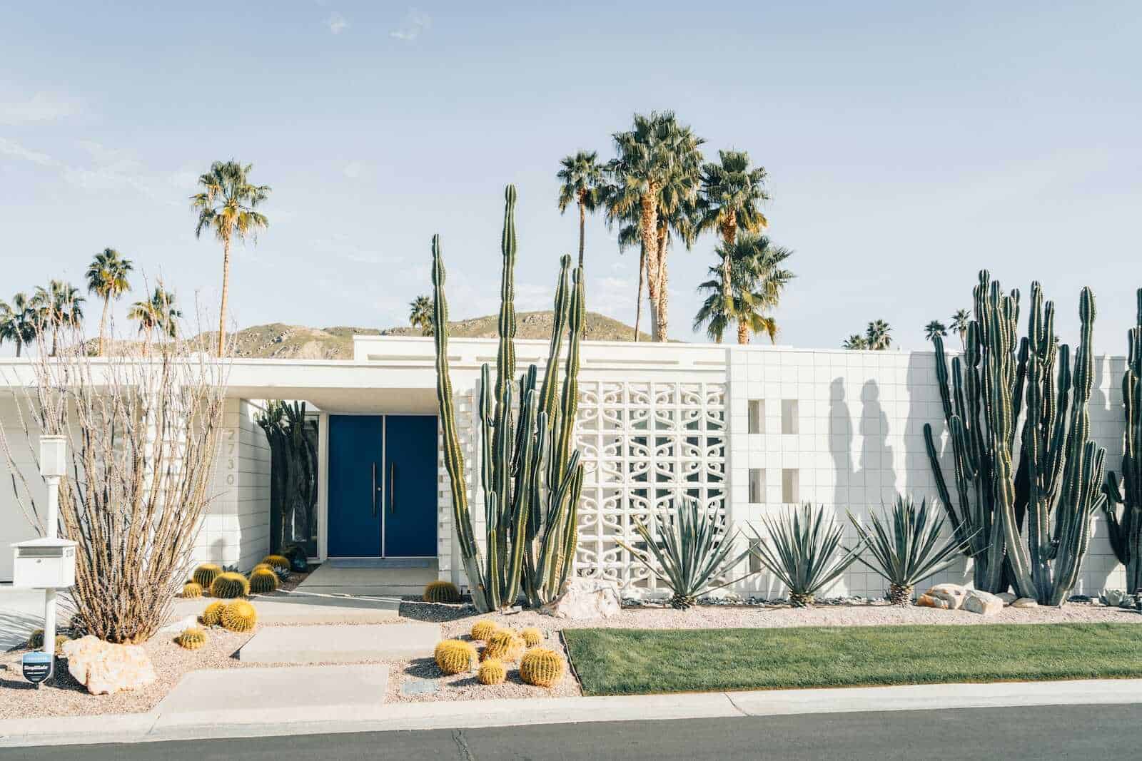 Stylish mid-century modern house with desert landscape and abundant cacti in Palm Springs, California.